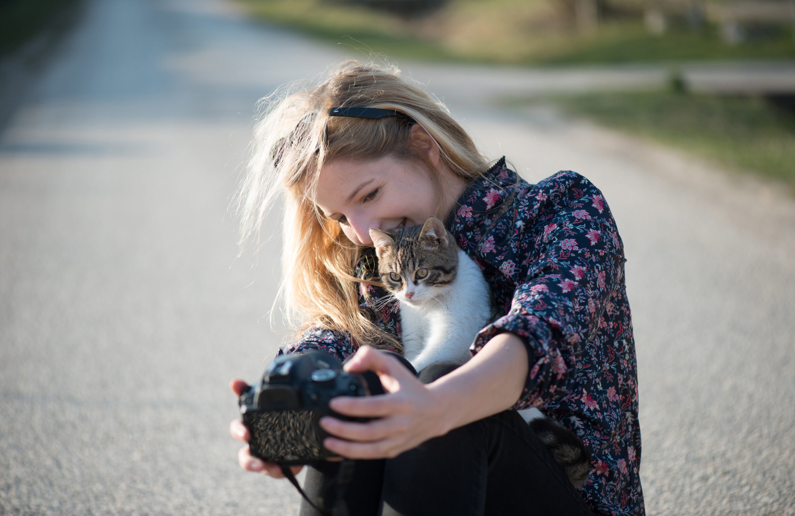 Cute blonde woman taking self portrait with a cat